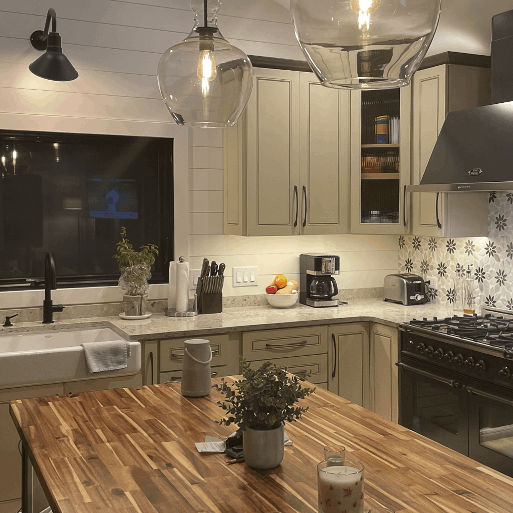 Remodeled modern kitchen in West Michigan home featuring beige shaker cabinets, quartz counters, farmhouse sink, and black hardware